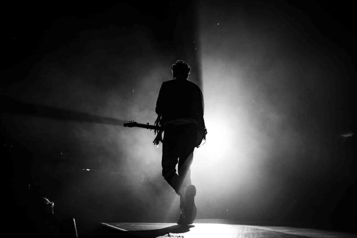 man with a guitar singing on stage